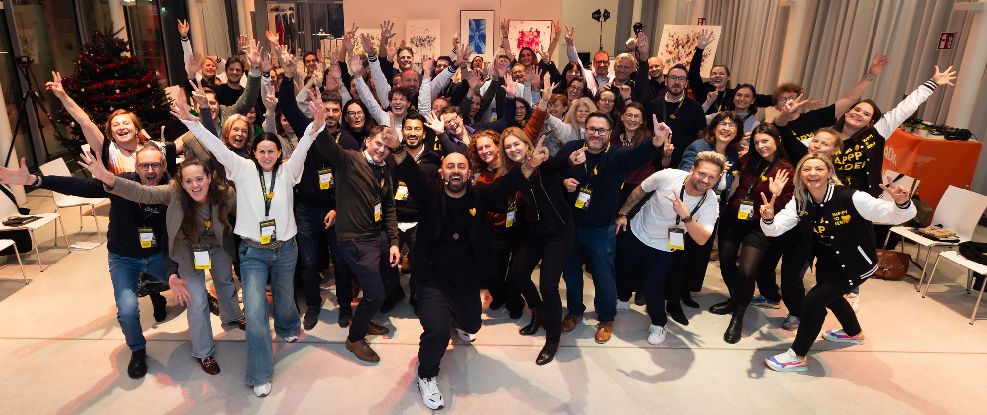 Ali Mahlodji in the middle, surrounded by around seventy participants of the Future Leadership Day, all cheering into the camera with raised arms