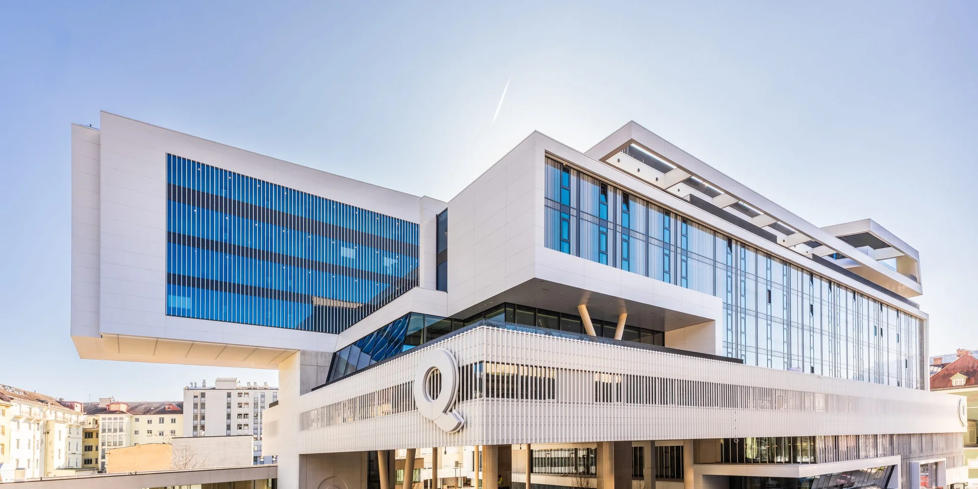 DAS RAIQA in Innsbruck, ein moderner heller Bau mit Glasfassaden vor blauem Himmel – Ort des Future Leadership Day Innsbruck