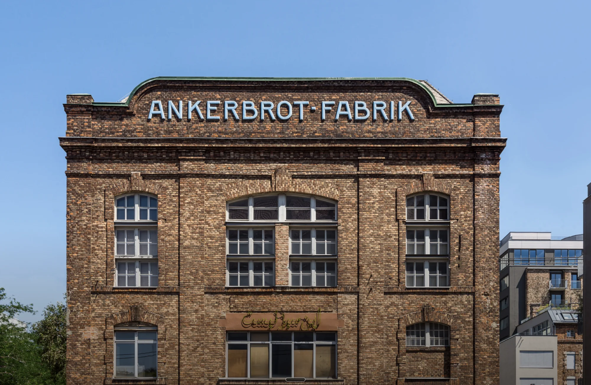 Backsteinfassade der Ankerbrot-Fabrik in Wien mit dem historischen Schriftzug „Ankerbrot-Fabrik“ vor blauem Himmel – Ort des Future Leadership Day Wien