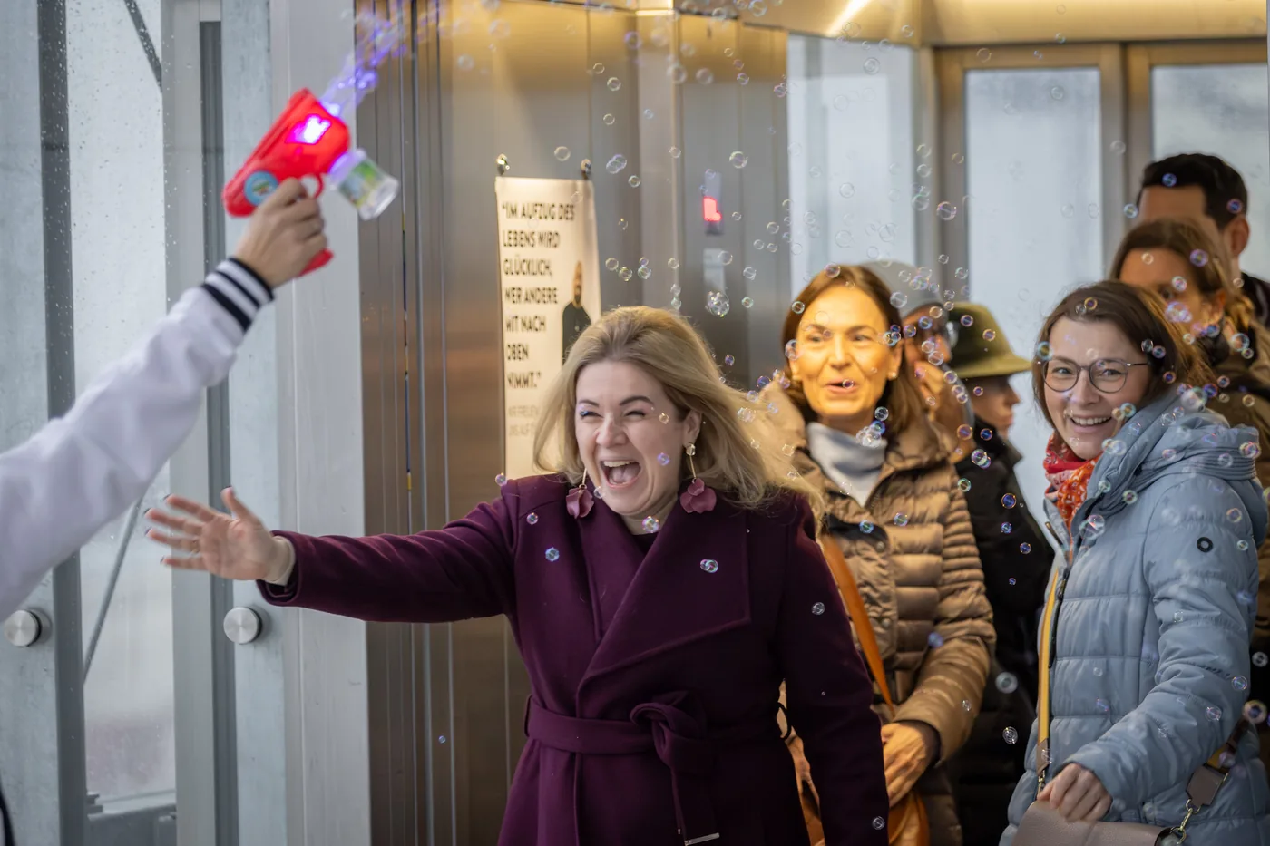 A participant beaming with outstretched arms, soap bubbles all around
