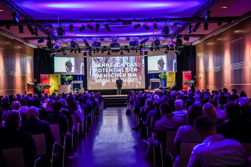 Ali Mahlodji on stage, portrait with headset