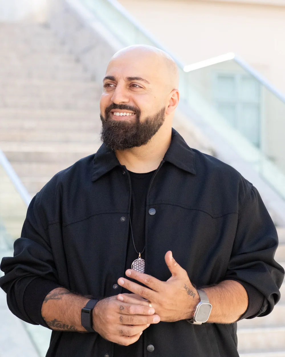 Ali Mahlodji, portrait, smiling on a staircase