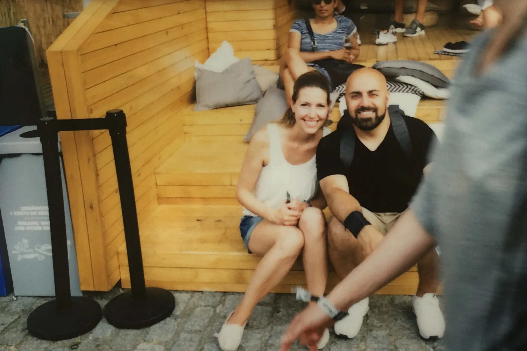 Anna and Ali laughing on a wooden bench at the Sónar festival in Barcelona in June 2017, instant photo
