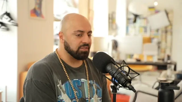 Ali Mahlodji im Studio am Mikrofon, Standbild aus der ersten Video-Folge