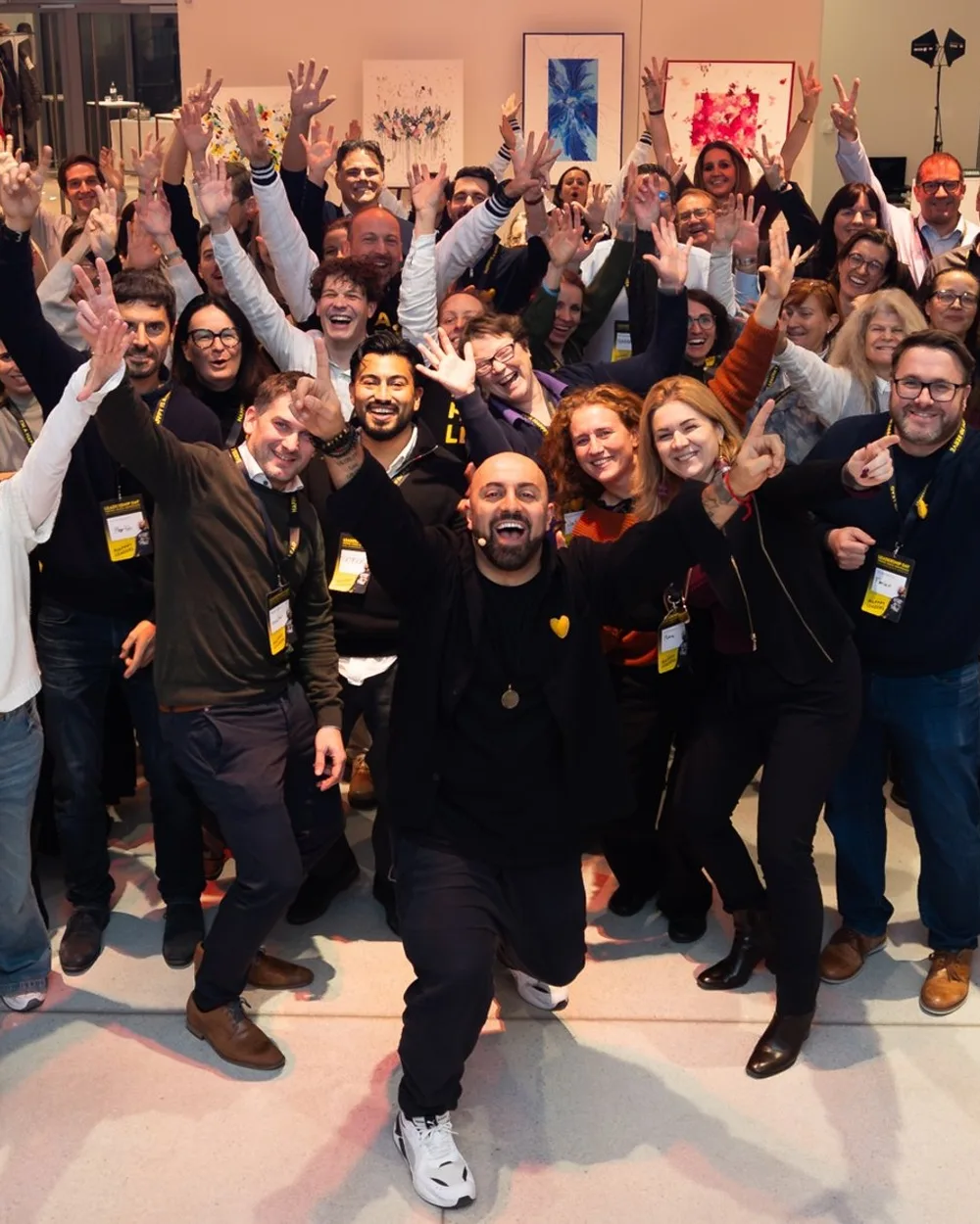 Ali Mahlodji mit den Teilnehmenden der HAPPY LEADERS in Wien 2025, alle mit erhobenen Armen